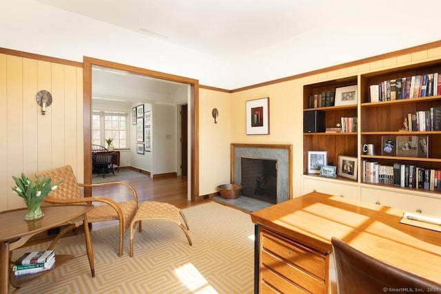 interior space featuring a premium fireplace, wood finished floors, and wooden walls