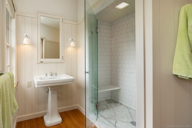 bathroom with a stall shower, a sink, and baseboards