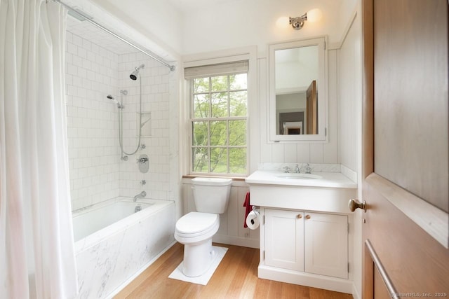 bathroom featuring vanity, shower / bath combo, wood finished floors, and toilet