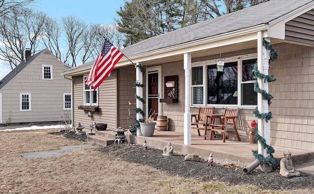 exterior space with covered porch and a shingled roof