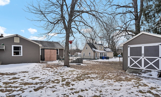 yard covered in snow with a storage shed and an outdoor structure