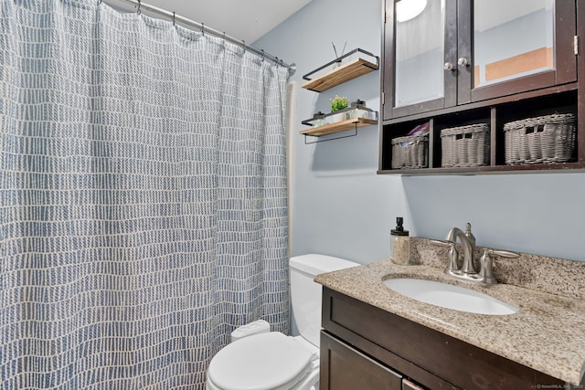 bathroom featuring curtained shower, toilet, and vanity