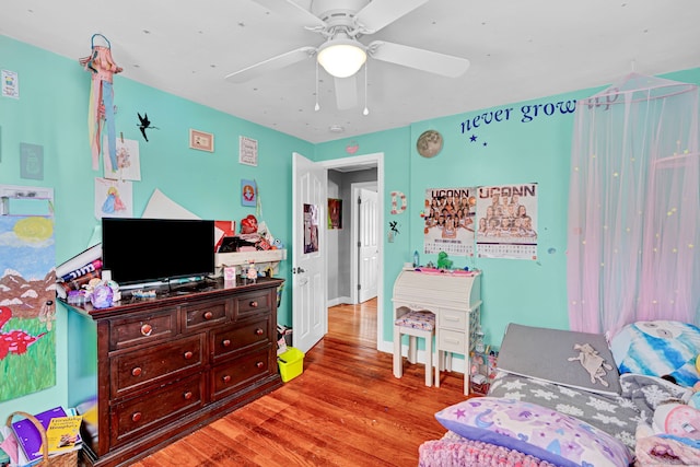 bedroom featuring baseboards, wood finished floors, and a ceiling fan