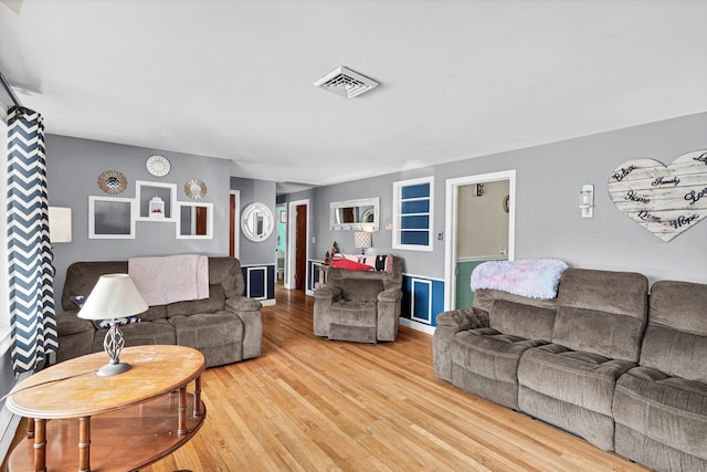 living room featuring visible vents and wood finished floors