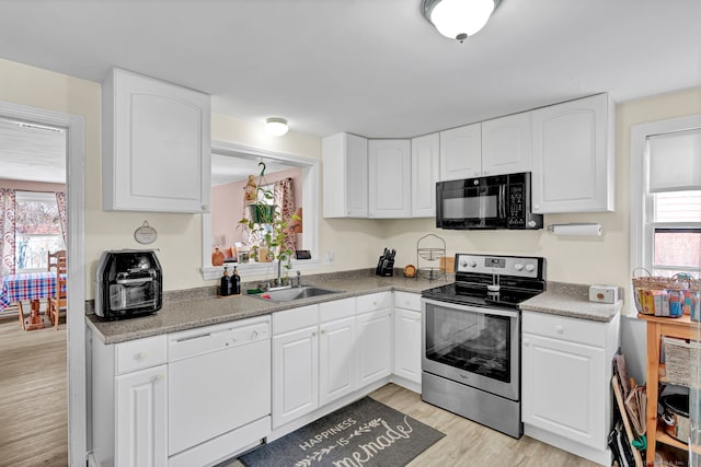 kitchen featuring a sink, stainless steel electric range, black microwave, light wood finished floors, and dishwasher