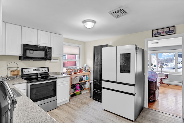 kitchen with visible vents, stainless steel range with electric cooktop, light wood-style floors, white cabinets, and black microwave