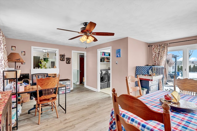 dining space featuring washer and dryer, baseboards, light wood finished floors, and ceiling fan