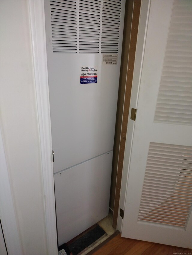 interior details featuring a heating unit, wood finished floors, and visible vents