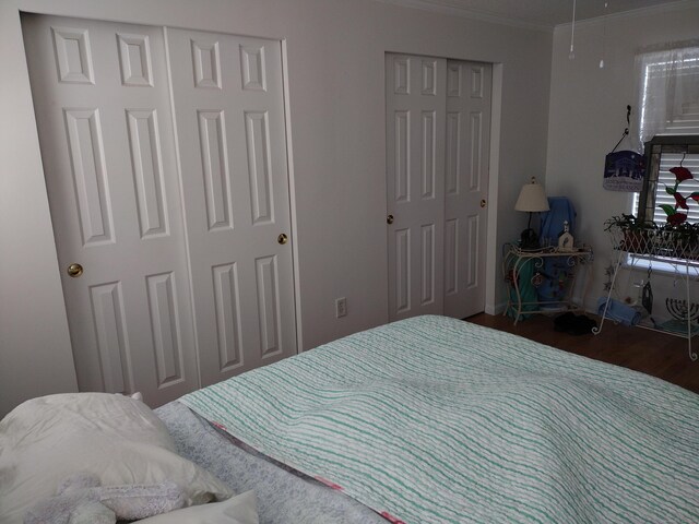 bedroom featuring wood finished floors and crown molding