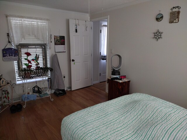 bedroom featuring crown molding and wood finished floors