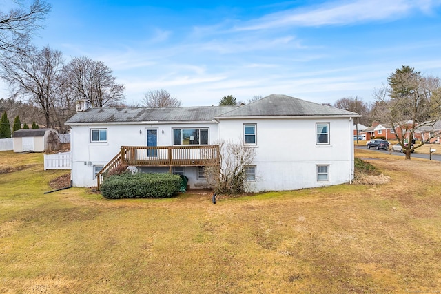 rear view of house featuring a lawn and a deck