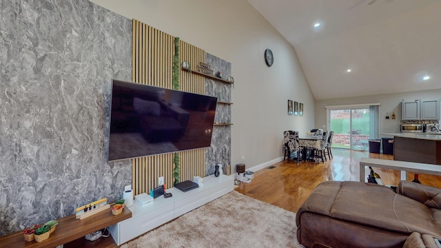 living room featuring high vaulted ceiling, recessed lighting, wood finished floors, and baseboards