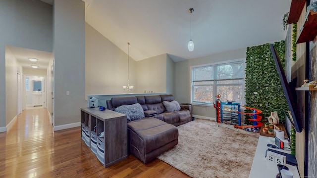 living room featuring high vaulted ceiling, wood finished floors, and baseboards