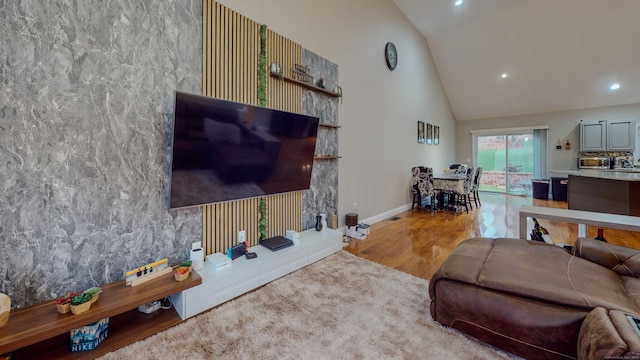 living room featuring baseboards, high vaulted ceiling, wood finished floors, and recessed lighting