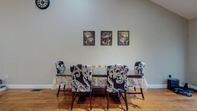 dining area with vaulted ceiling, wood finished floors, visible vents, and baseboards