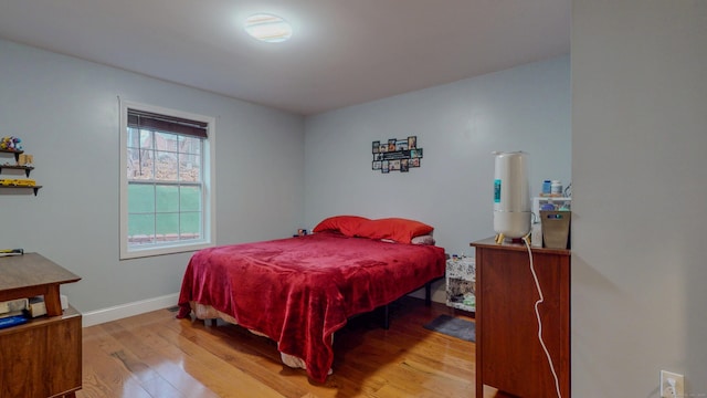 bedroom featuring hardwood / wood-style flooring and baseboards