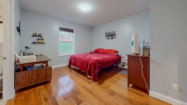 bedroom with light wood-type flooring and baseboards