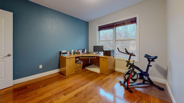 office space with light wood-type flooring and baseboards