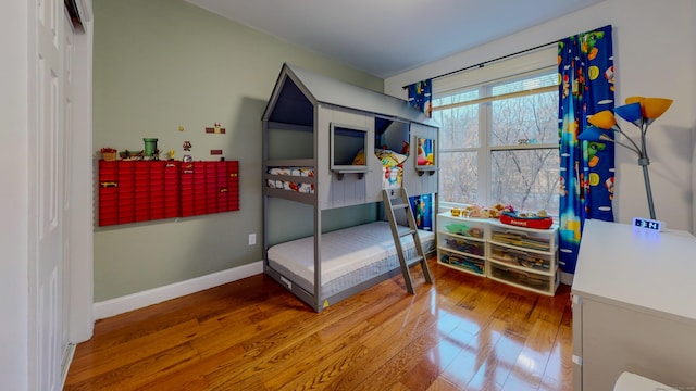 bedroom featuring a closet, hardwood / wood-style flooring, and baseboards