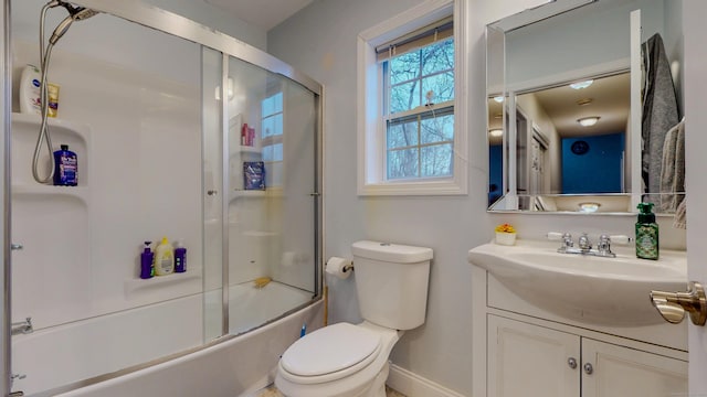 bathroom featuring shower / bath combination with glass door, vanity, toilet, and baseboards