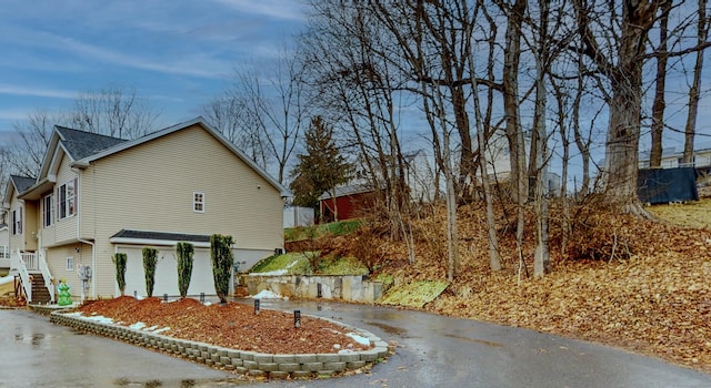 view of property exterior with stairs and driveway