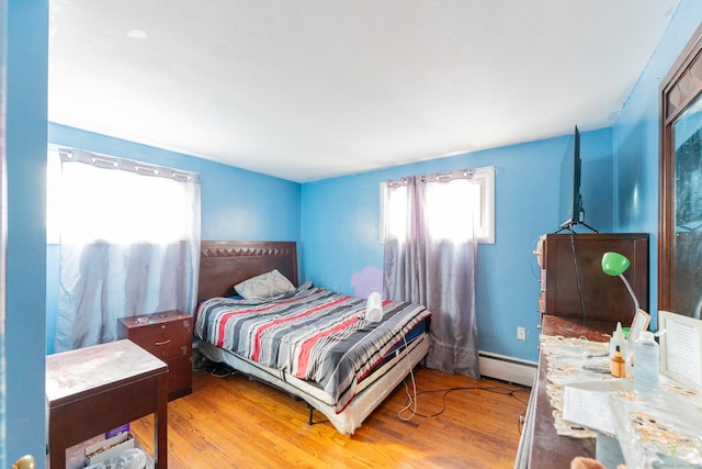 bedroom featuring a baseboard radiator and wood finished floors