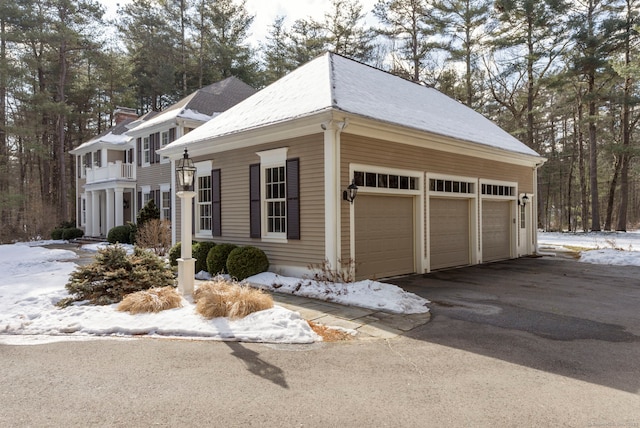 view of snowy exterior featuring aphalt driveway