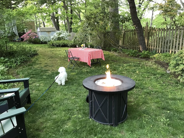 view of yard with fence and a fire pit