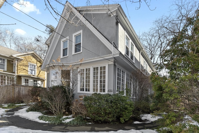 view of side of property featuring fence and stucco siding