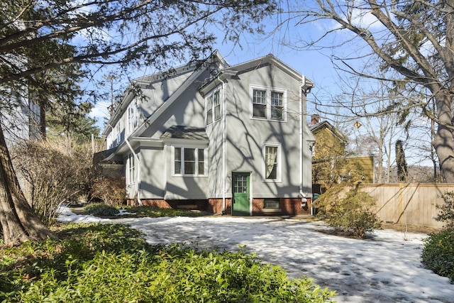 view of front of home featuring fence, driveway, and stucco siding