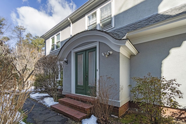 doorway to property featuring roof with shingles, french doors, and stucco siding