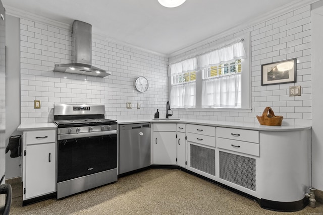 kitchen featuring white cabinets, wall chimney exhaust hood, ornamental molding, stainless steel appliances, and a sink