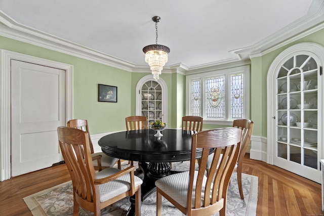 dining space with crown molding and a notable chandelier