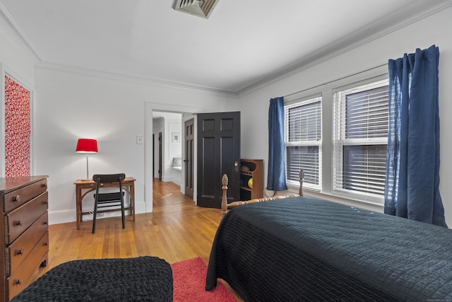 bedroom with ornamental molding, light wood-type flooring, visible vents, and baseboards