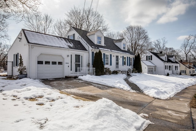 cape cod-style house featuring driveway and an attached garage