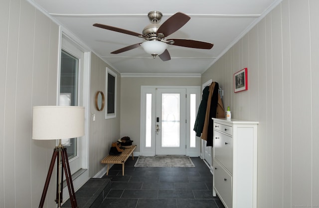 foyer with a ceiling fan and crown molding