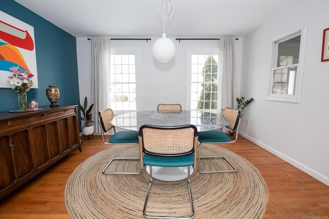 dining room with light wood-type flooring and baseboards