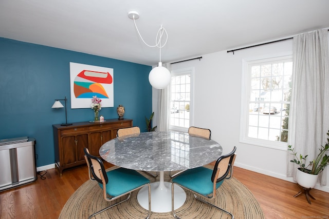 dining room featuring wood finished floors and baseboards