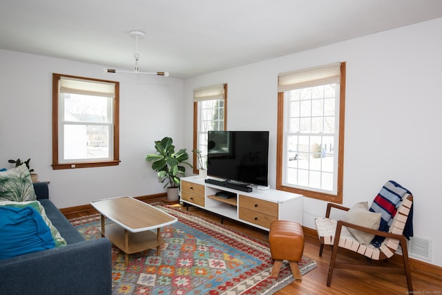 living room featuring baseboards, a wealth of natural light, and wood finished floors