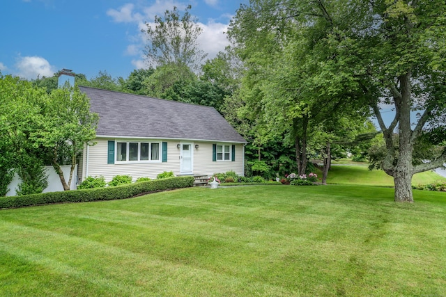 view of front of property with a front lawn, a chimney, and a shingled roof