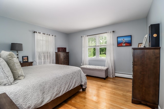 bedroom with light wood-type flooring and baseboard heating