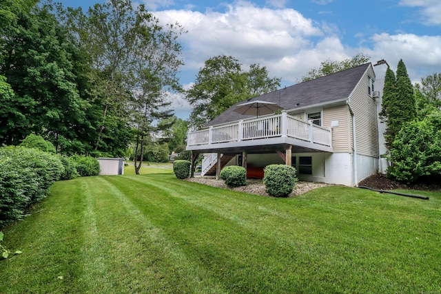 back of house featuring a chimney, stairway, a deck, and a yard