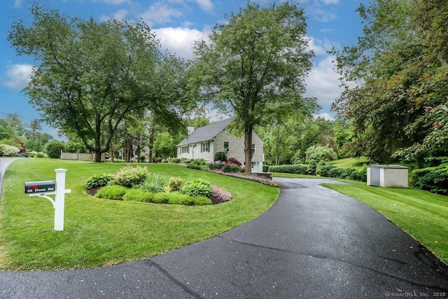 view of front of home with driveway and a front lawn