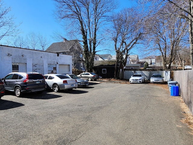 uncovered parking lot with a residential view and fence