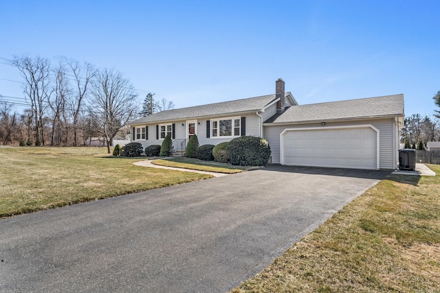 ranch-style home with a shingled roof, a front yard, a chimney, driveway, and an attached garage