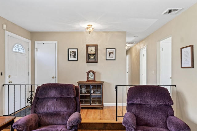 sitting room with visible vents, baseboards, and wood finished floors