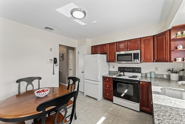 kitchen with stainless steel microwave, visible vents, range with electric stovetop, freestanding refrigerator, and open shelves