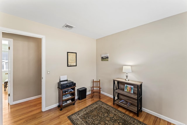 sitting room with light wood-type flooring, baseboards, and visible vents