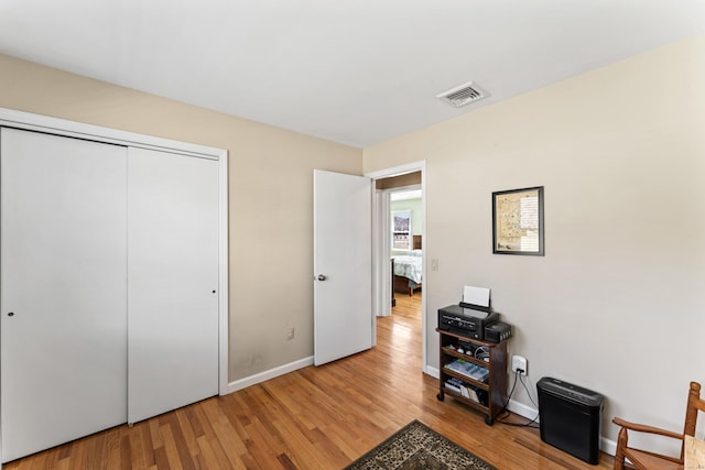 interior space featuring wood finished floors, visible vents, and baseboards