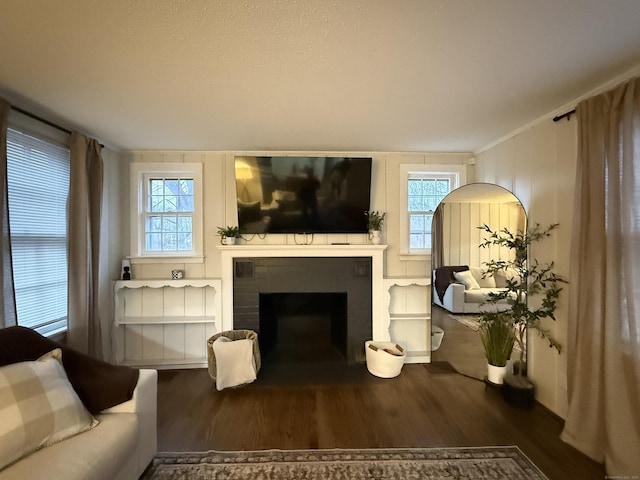 living room featuring a fireplace with flush hearth and wood finished floors